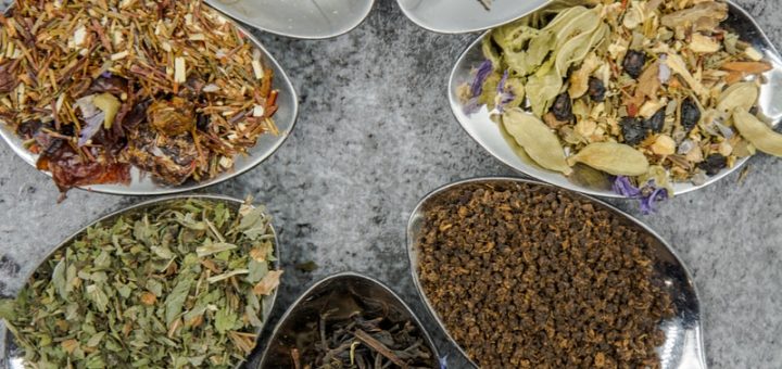 seven different herbs in gray spoons