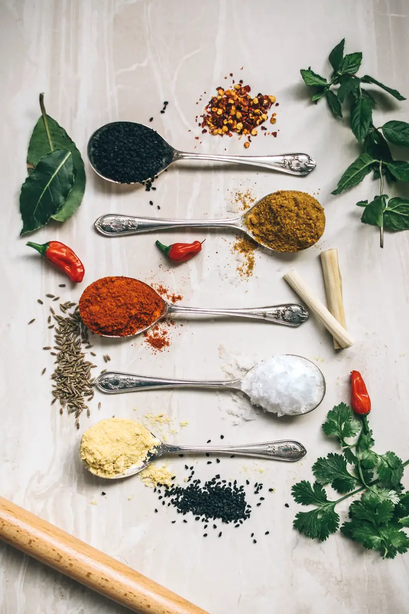 five spoons filled with spices