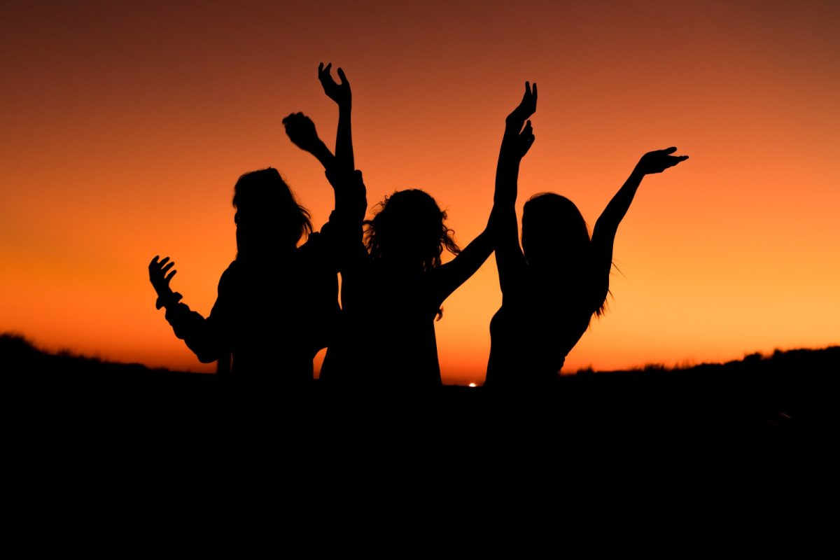 silhouette of women laughing during sunset