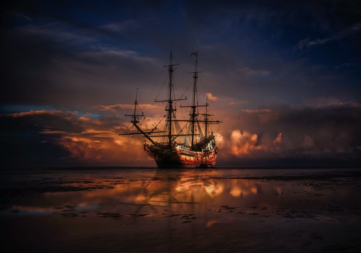 pirate ship on sea during sunset