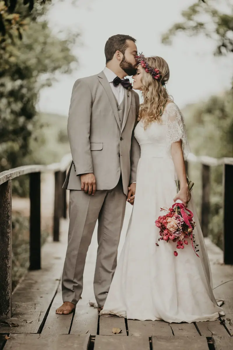 groom kissing his bride on the forehead