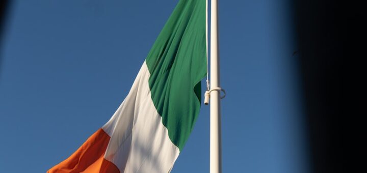 Irish Flag Fluttering In The Blue Sky